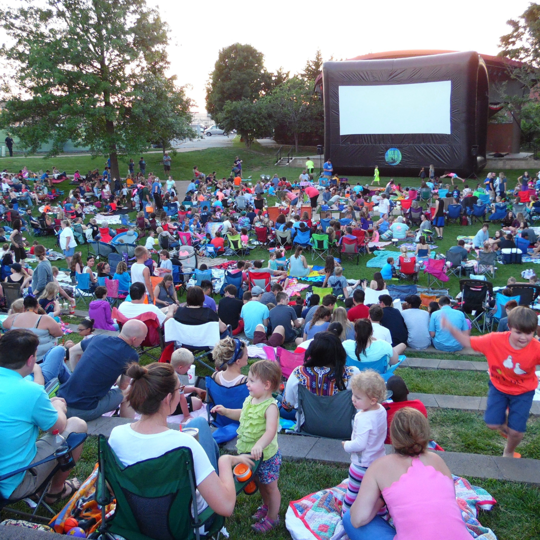 large crowd watching movie outside at dogwood park 